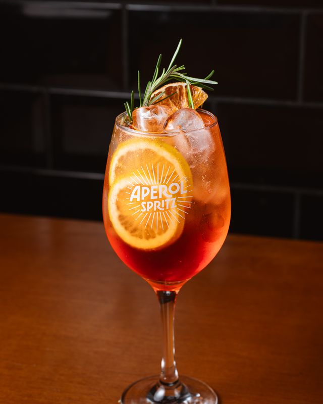 Aperol Spritz com laranja desidratada e alecrim