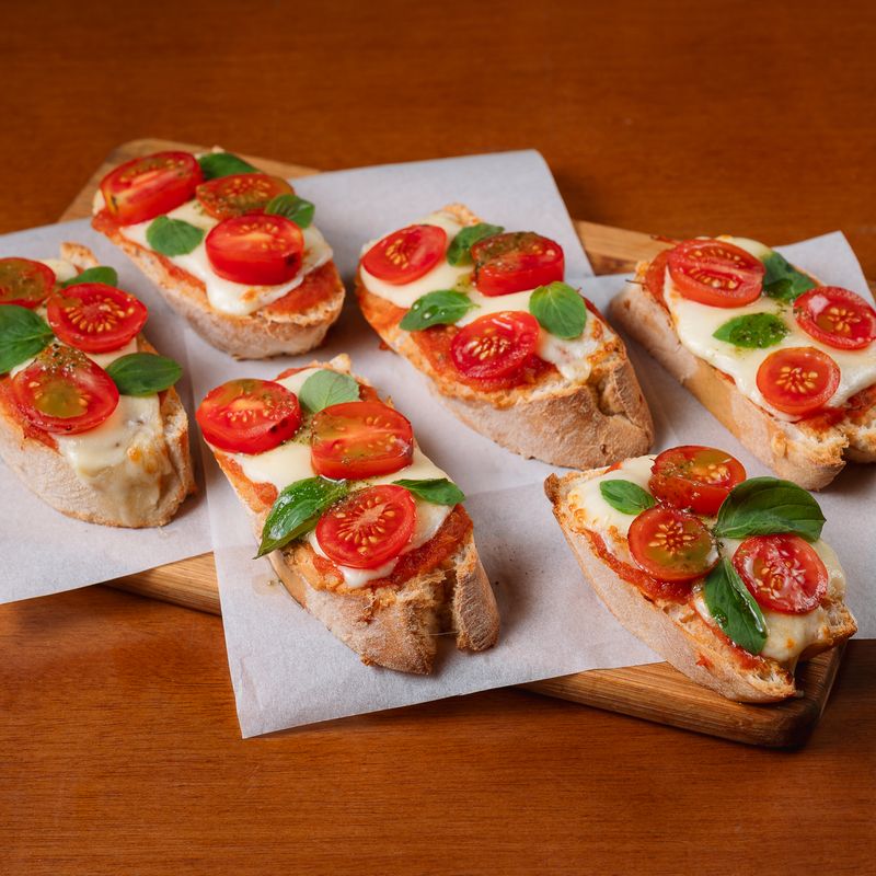 Bruschettas caprese com tomate cereja, queijo e manjericão