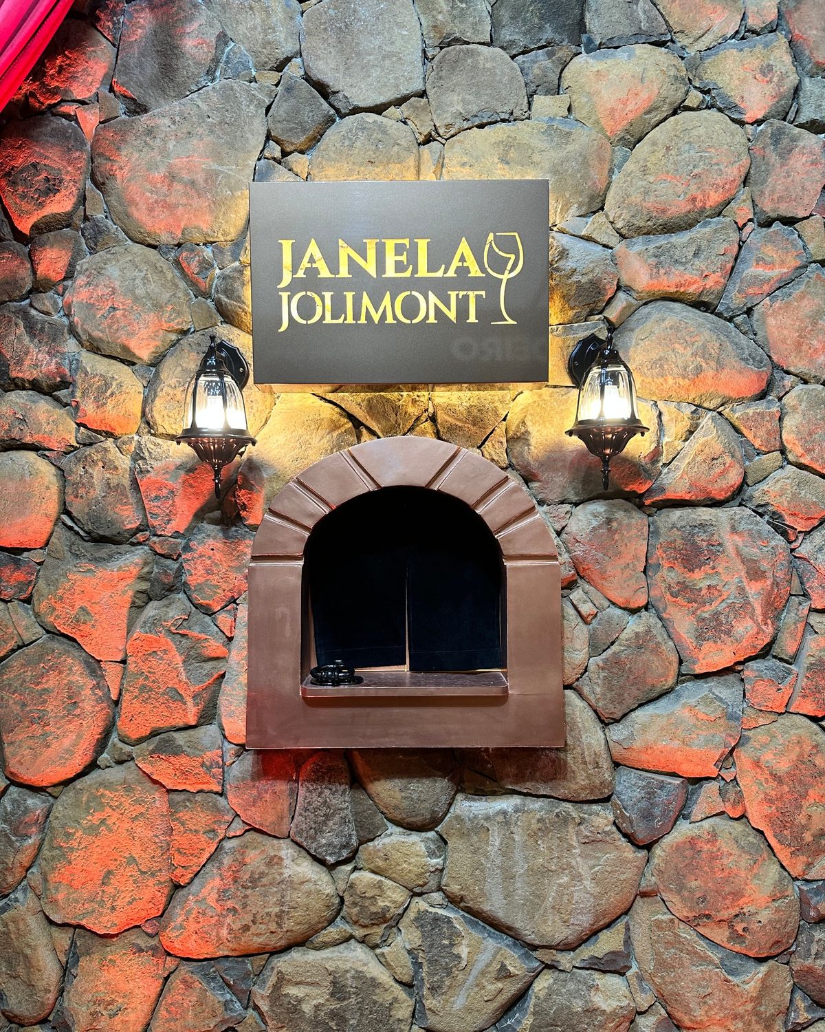 Janela Jolimont: a janela em arco na parede de pedra, com a placa iluminada e duas lanternas