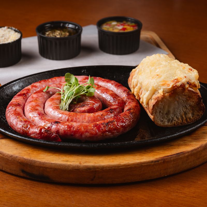 Linguiça artesanal na chapa, com pão de alho gratinado e molhos